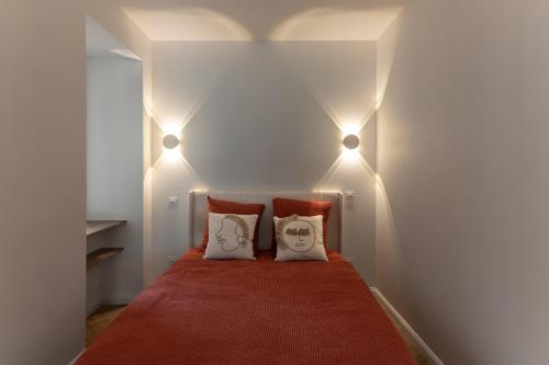 a bedroom with two pillows on a bed with lights at La Loge du Roi Arthur in Campénéac