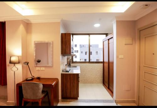 a room with a desk and a kitchen at Queen Hotel in Addis Ababa