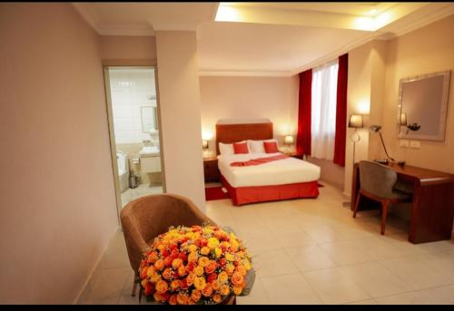 a hotel room with a bed and a chair and a desk at Queen Hotel in Addis Ababa