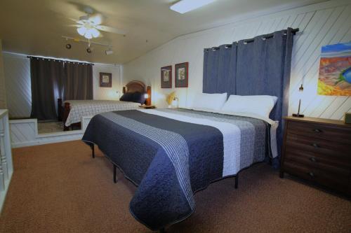 a bedroom with a large bed with a blue and white blanket at Paddleboards, Air Hockey, Grill, Fire Pit, WD, Brkfst, Sleeps 10, upper in Page