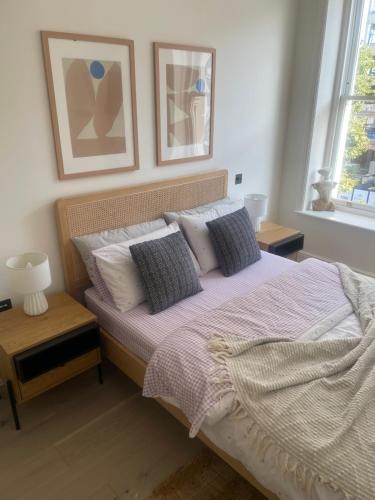 a bedroom with a large bed with pillows at Northwest Apartment in London
