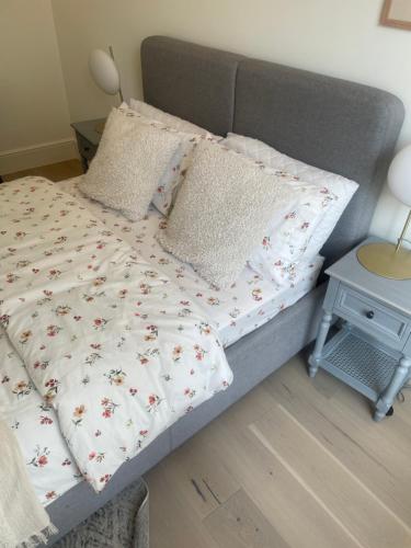 a bedroom with a bed with a white bedspread with flowers at Northwest Apartment in London