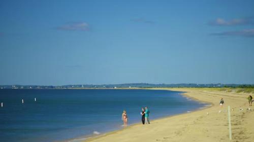 a group of people walking on the beach at Water View Home with Hot Tub Balcony Pool and Tennis in Mashpee