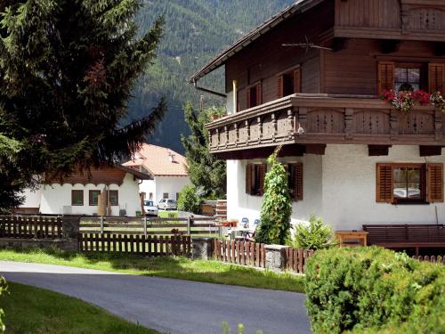 a large wooden house with a fence in front of it at Apartment in Austria with Mountain Views in Längenfeld