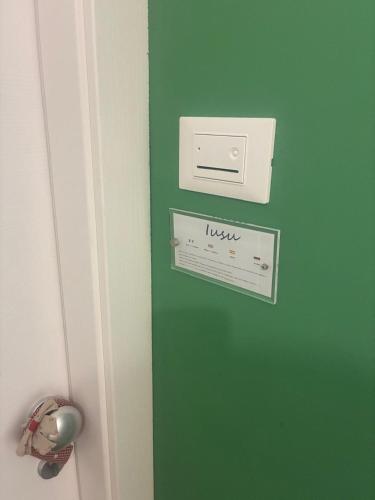 a door with a green wall with a sign on it at Reusuite in Ragusa