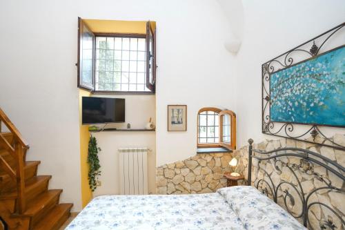 a bedroom with a bed and a tv on the wall at Tramonti Divini - Amalfi Coast Country House in Tramonti