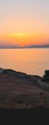 a sunset over a body of water with the horizon at Nefeli's House in Souvala