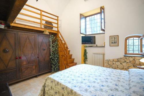 a bedroom with a bed and a wooden staircase at Tramonti Divini - Amalfi Coast Country House in Tramonti