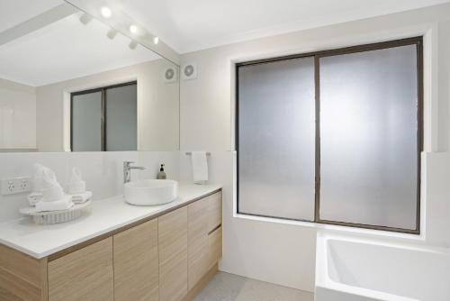 a white bathroom with a sink and a mirror at Anderlaine at Wootha in Booroobin
