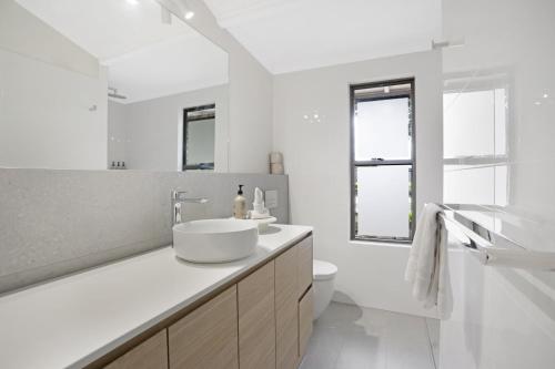 a white bathroom with a sink and a toilet at Anderlaine at Wootha in Booroobin