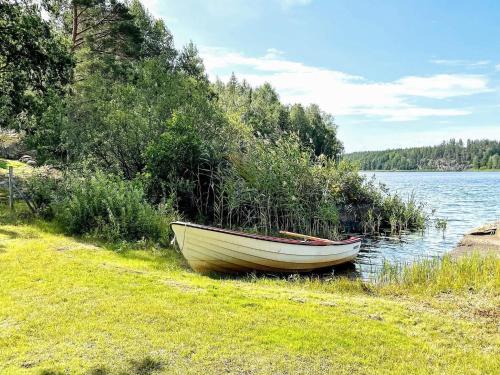 a small boat sitting on the shore of a lake at 8 person holiday home in VALDEMARSVIK in Valdemarsvik