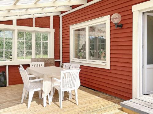 a patio with a table and chairs on a red wall at 8 person holiday home in VALDEMARSVIK in Valdemarsvik