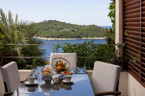 Una mesa con un bol de fruta y vista al océano. en Villa King, en Dubrovnik