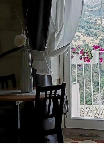 a table and a chair in a room with a window at Reusuite in Ragusa