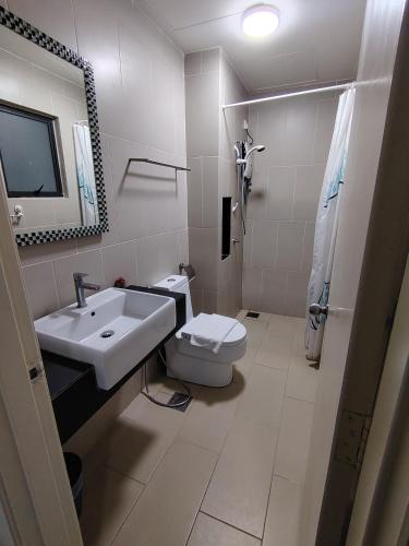 a bathroom with a sink and a toilet and a mirror at Swiss Garden resort residence by Moonlight in Kuantan
