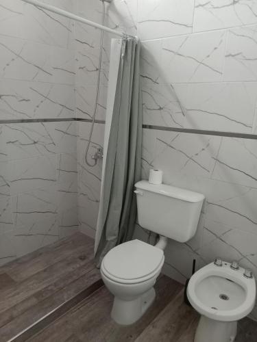a white bathroom with a toilet and a shower at Departamentos DOÑA ELBA in Colorado River