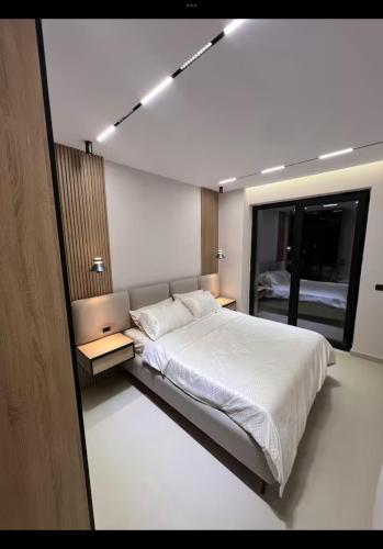 a bedroom with a large bed and a mirror at Sweet HOME in Shëngjin