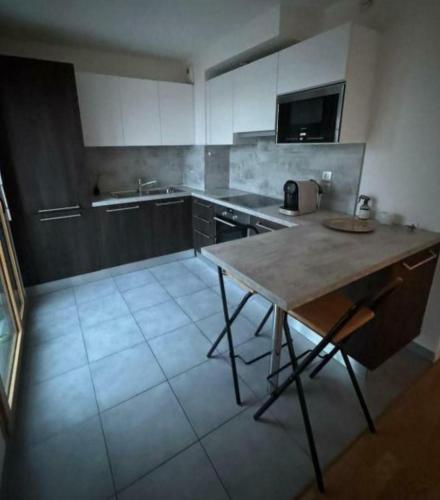 una cocina con una mesa en el medio. en STUDIO Etoile 74, en Annemasse
