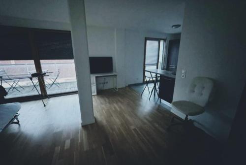 Una sala de estar con una mesa y sillas y un televisor. en STUDIO Etoile 74, en Annemasse