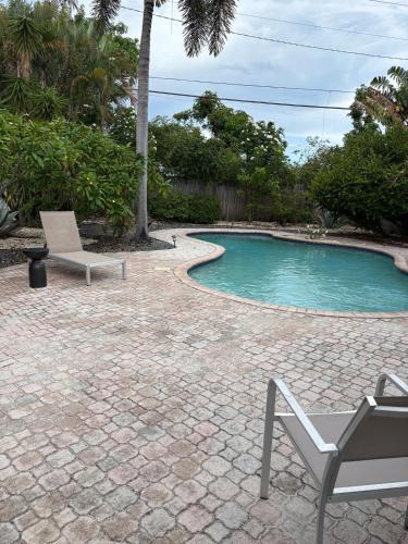 a patio with a chair and a swimming pool at Mid-Century with Outdoor Oasis in Fort Lauderdale