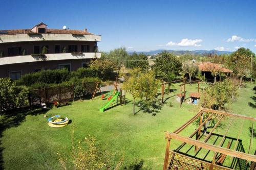 a large yard with a playground in front of a building at Iscairia Country House in Ascea