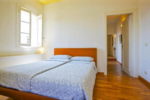 a bedroom with a bed with blue sheets and a window at Appartamento Ronco in Ghiffa