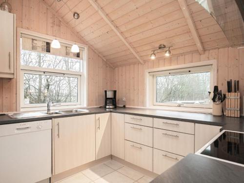 a kitchen with white cabinets and black counter tops at 6 person holiday home in Vinderup-By Traum in Vinderup