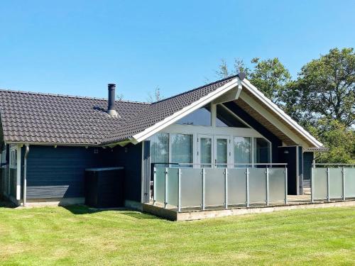a blue house with a porch and a lawn at 6 person holiday home in Vinderup-By Traum in Vinderup