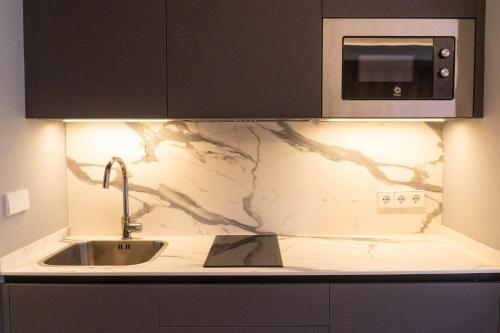 a kitchen counter with a sink and a microwave at Caño in Pincelo