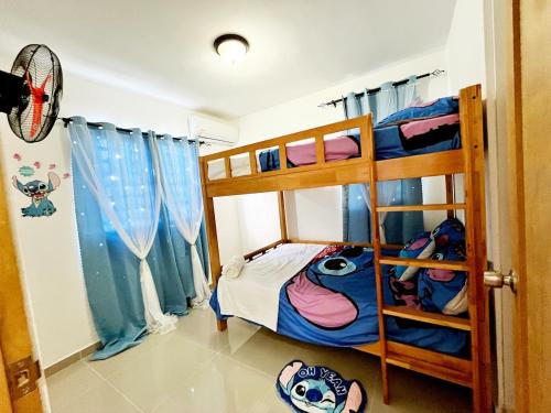 a bedroom with two bunk beds with blue curtains at Ideal space for the family in Boca Chica