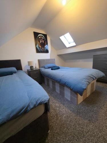a attic bedroom with two beds and a skylight at Alphonsus Home in Middlesbrough in Middlesbrough
