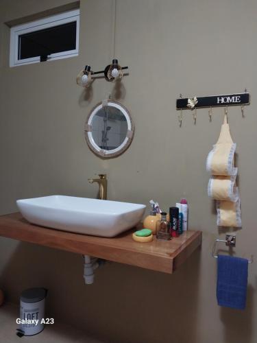 a bathroom with a white sink and a mirror at Angel's Appt in Rivière Noire