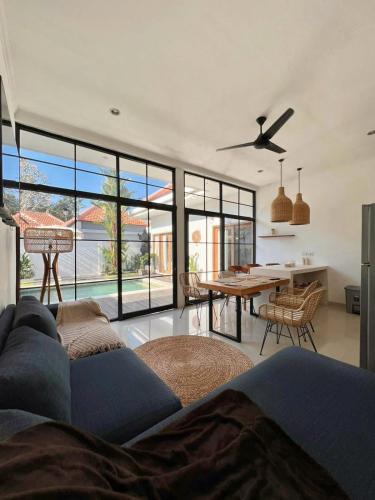 a living room with a couch and a ceiling fan at Villa Obo Pererenan by REJA Villas in Munggu