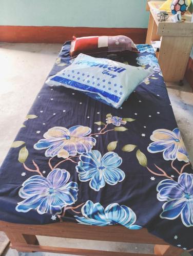 un letto con fiori blu sopra in una stanza di Golden Green Guest House a Bokāro
