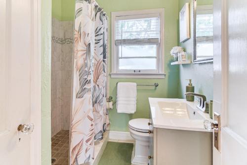 ein Badezimmer mit Toilette und Waschbecken und einem Fenster in der Unterkunft St Pete Home for Retreat and Corporate Travelers in St Petersburg