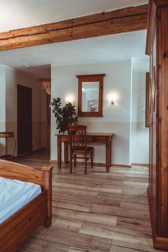 a room with a table and a chair and a desk at Landhotel Kahrmühle in Pressath