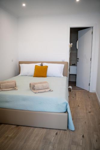 a bedroom with a large bed with two towels on it at Riad'a Praia in Armação de Pêra