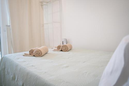 a white bed with towels on top of it at Riad'a Praia in Armação de Pêra