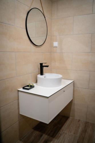 a bathroom with a white sink and a mirror at Riad'a Praia in Armação de Pêra