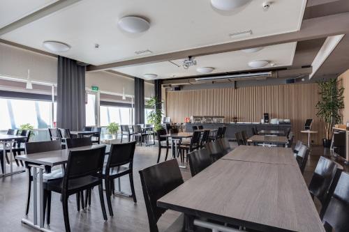 un ristorante con tavoli e sedie in legno e una caffetteria di Hotel Käenpesä a Ylivieska