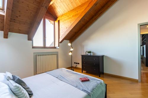 a bedroom with a large bed and a wooden ceiling at Casa Peku in Monza
