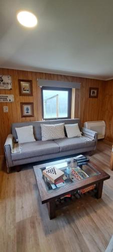 a living room with a couch and a coffee table at Refugio Verde Apartamento entero con entrada independiente in Puerto Varas