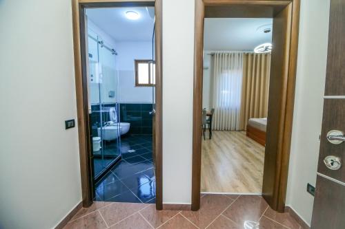 a bathroom with a glass shower and a toilet at The Blue House in Široka