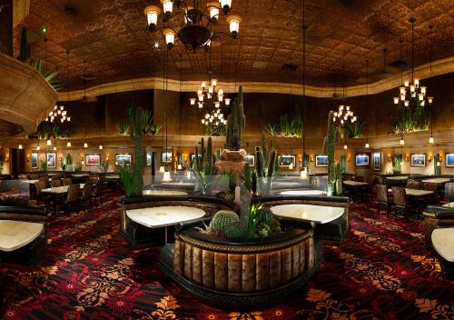 a restaurant with tables and chairs and potted plants at Peppermill Hotel Casino in W Wendover, Nevada in West Wendover