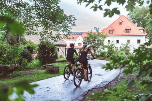 two people riding bikes down a road at Landhotel Kahrmühle in Pressath