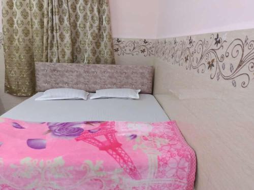 a bedroom with a bed with a pink blanket at Xavier's guesthouse Wi-Fi and Villa in Colva