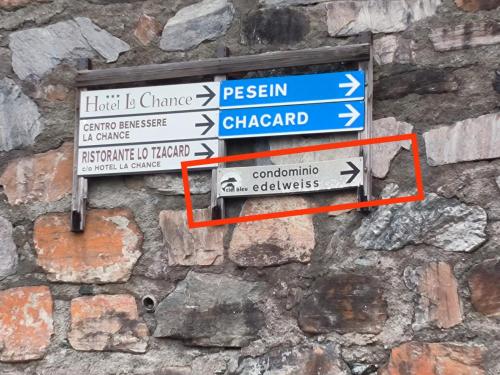 a bunch of street signs on a stone wall at Casa Andrea vista Monte Bianco in Pila