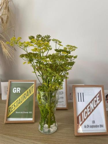 a vase with flowers in it sitting between two signs at paddock pétillant in Auménancourt-le-Grand