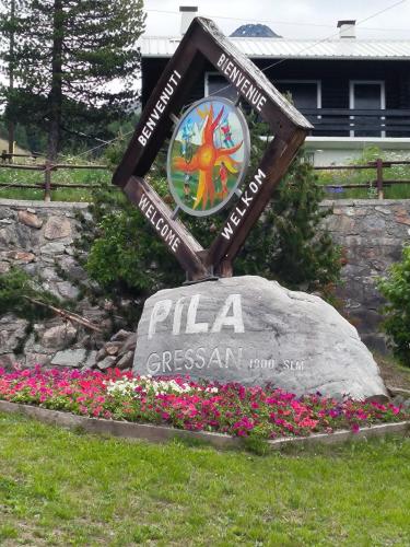 a sign for a pizza restaurant in a field of flowers at Casa Andrea vista Monte Bianco in Pila