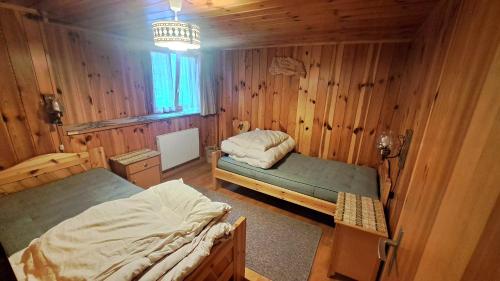 Un dormitorio con dos camas en una cabaña de madera. en FREE Bus Winter Haus Ramona, en Saas-Grund